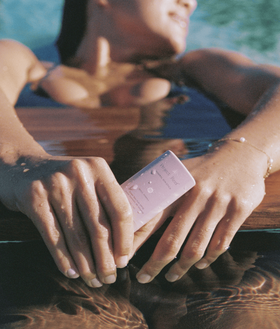 Girl in a bikini and in the water with Project Reef sunscreen