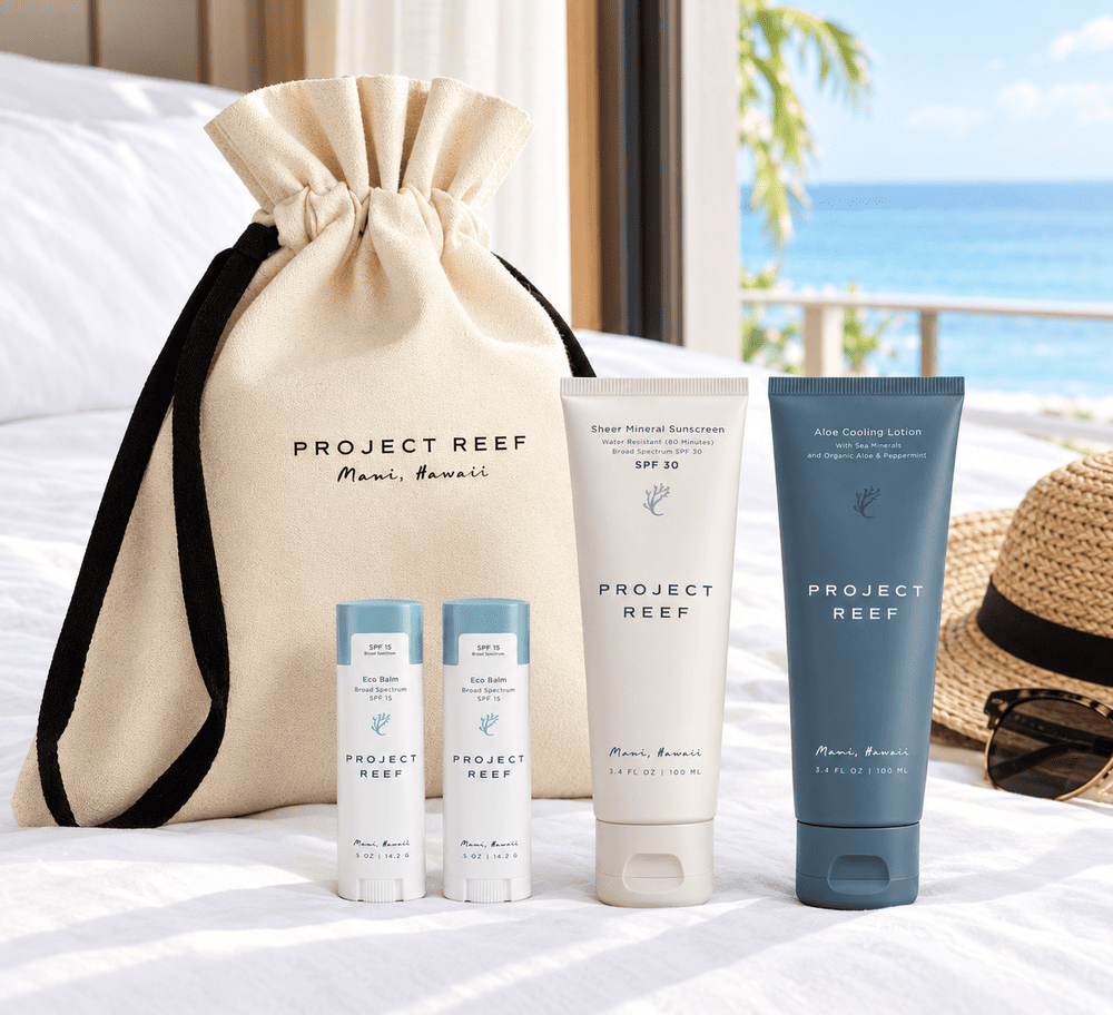 A luxury destination event gift bag on a white hotel bed, featuring reef-safe sun care products by Project Reef.
