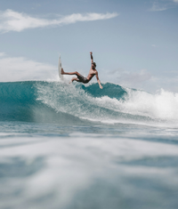 Surfer riding a wave protected by reef safe sun care.