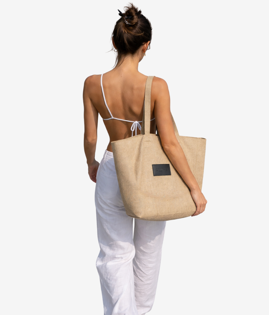 Woman carrying a beige tote bag ideal for carrying reef safe sunscreen and everyday essentials