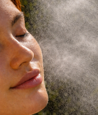 Person applying aloe vera cooling mist on her face