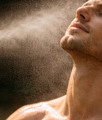 Close-up of a man applying aloe vera cooling mist to his face.