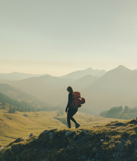 Hiker with a backpack on a grassy hill with an SPF50 Sunstick for sun protection.