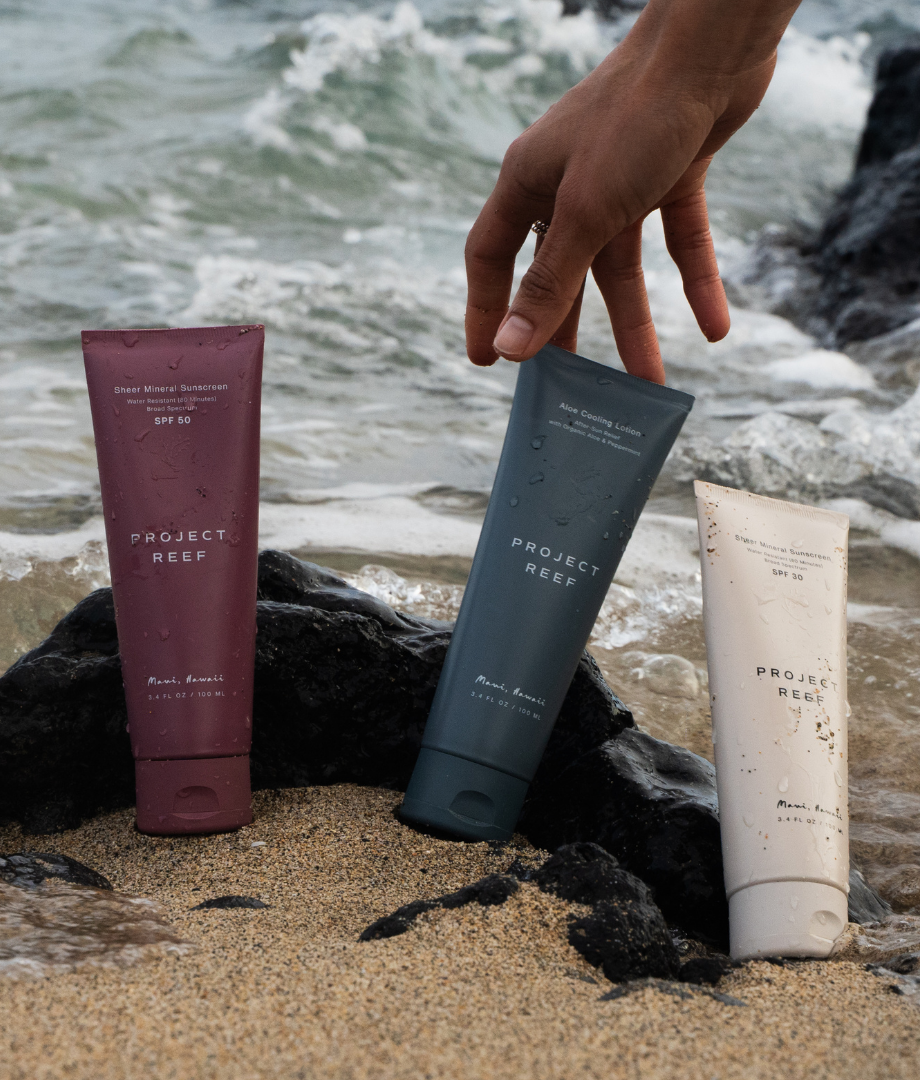 Three Project Reef suncare products on a beach 
