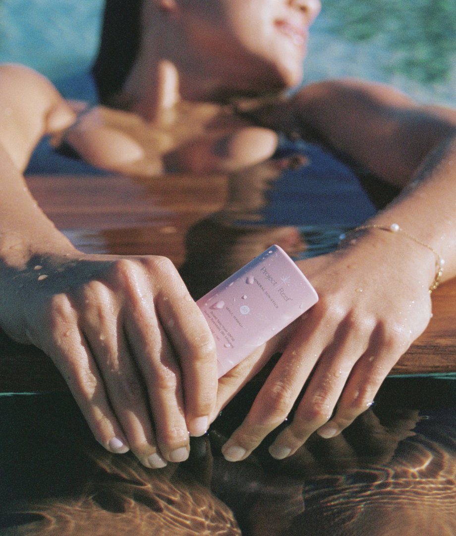 Girl in a bikini and in the water with Project Reef sunscreen 