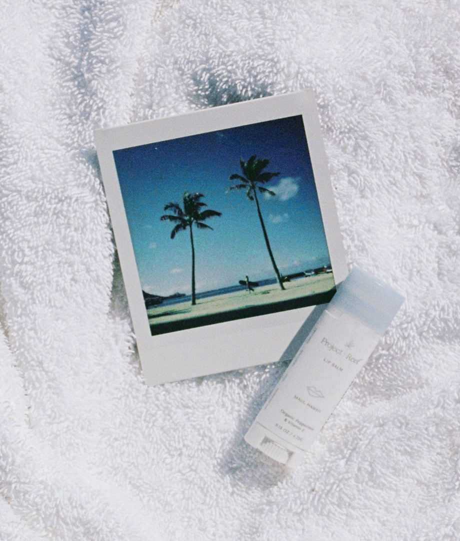 Picture of a polaroid image and Project Reef sunscreen on a towel