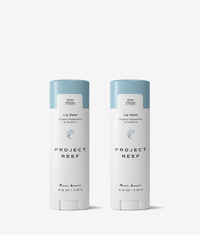 Two Project Reef lip balm sticks on a white background